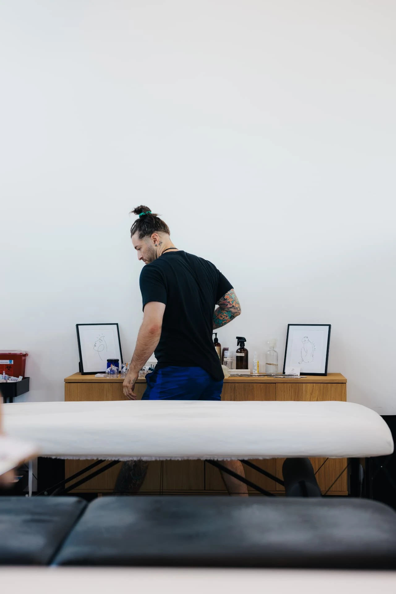 Travis preparing supplies behind a massage table